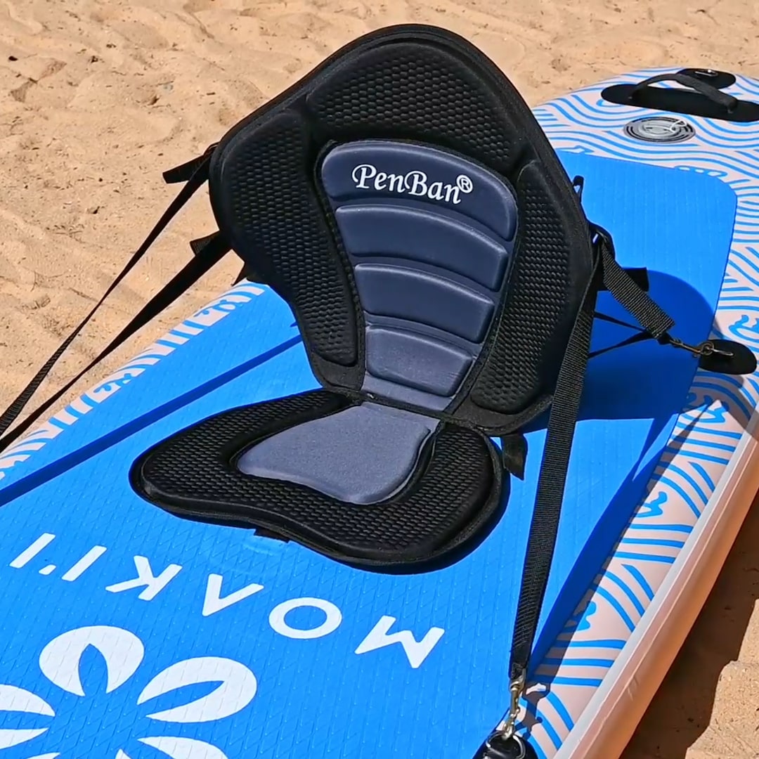 Blue paddleboard with a black kayak seat on a sandy background