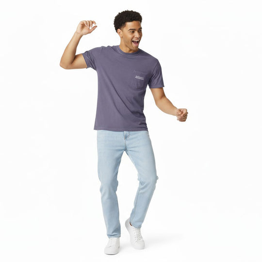 Man wearing a Moaki'i purple t-shirt and light blue jeans on a white background