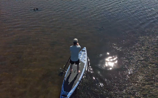 Aerial drone view of the Seeker touring board on a calm lake.