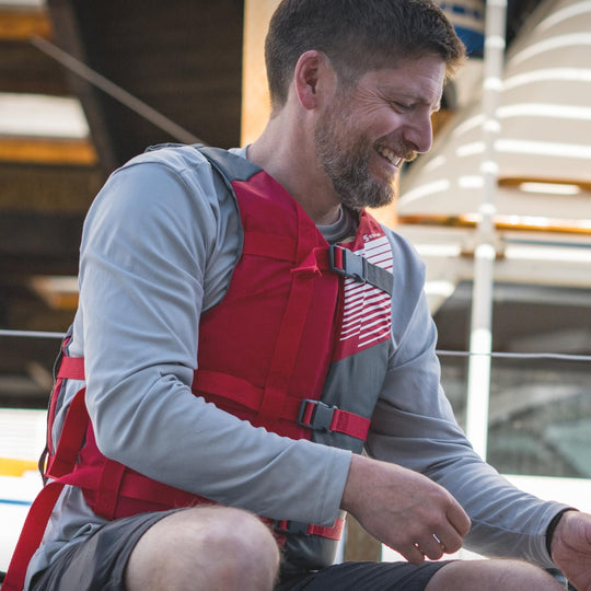 Man wearing a red life jacket on a boat
