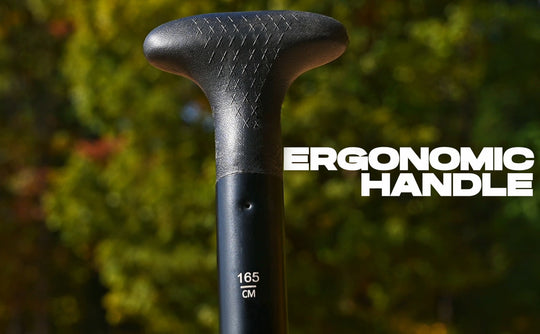 Close-up of an ergonomic handle with text indicating measurement, against a blurred natural background.