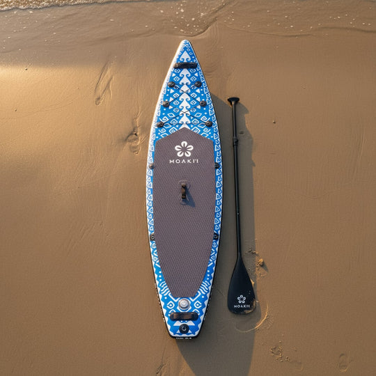 Vertical lifestyle shot of the Seeker 11'6" board on the beach at golden hour.