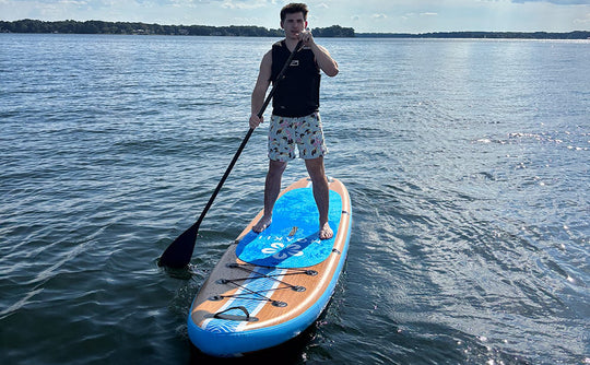 Man paddling the Moaki'i Kiva on calm water, highlighting its straight-line tracking for fitness.