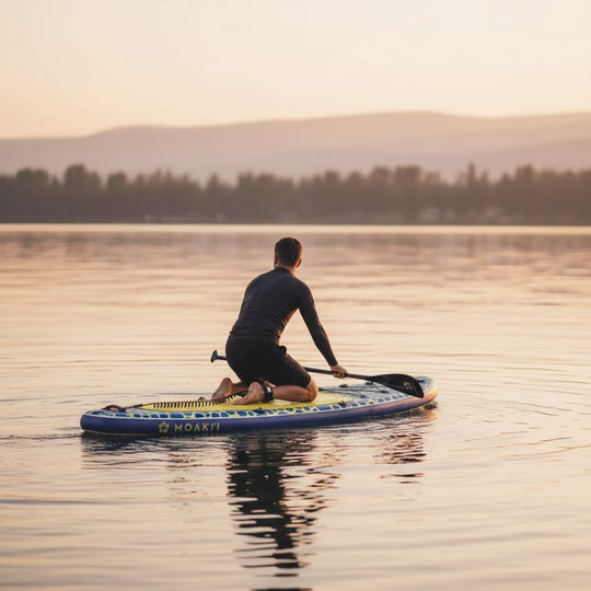 Paddler kneeling on the Trekker at sunset, showing the board's versatility for relaxed cruising.