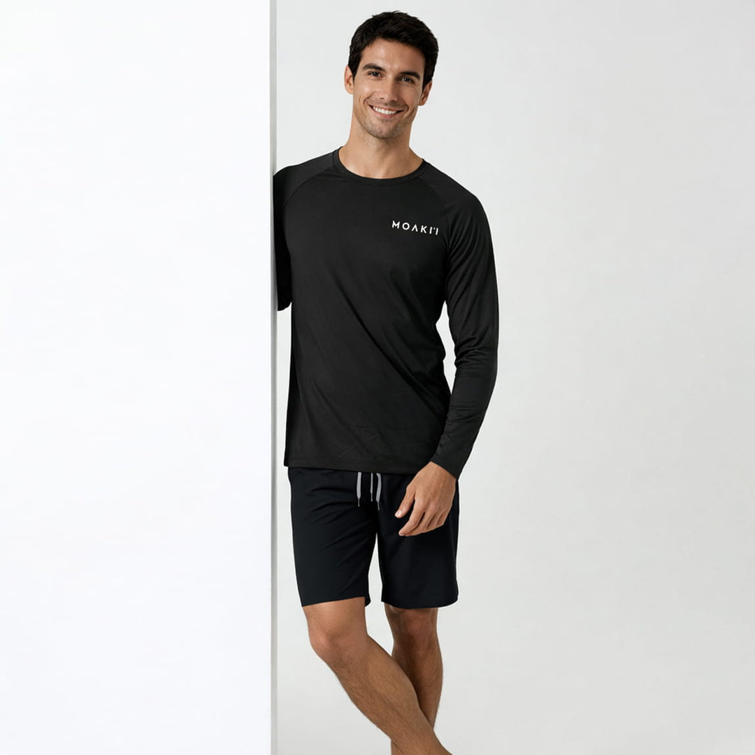Man wearing a black long-sleeve shirt and shorts with 'MOAKII' branding on a white background