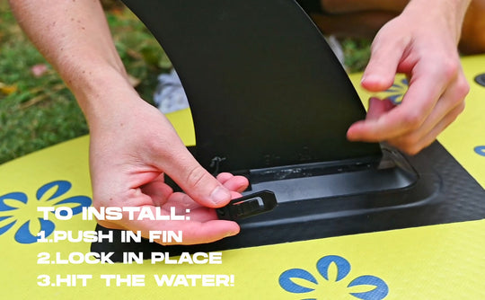 Person installing a fin on a paddleboard with text instructions.