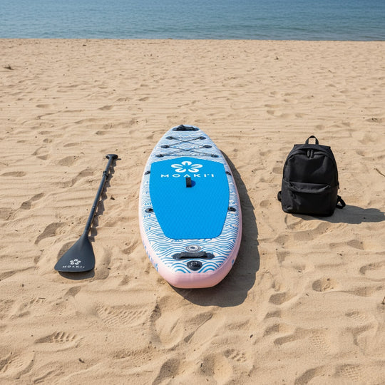 The Moaki'i Trekker resting on a lake shore, highlighting its vibrant blue and pink wave design.