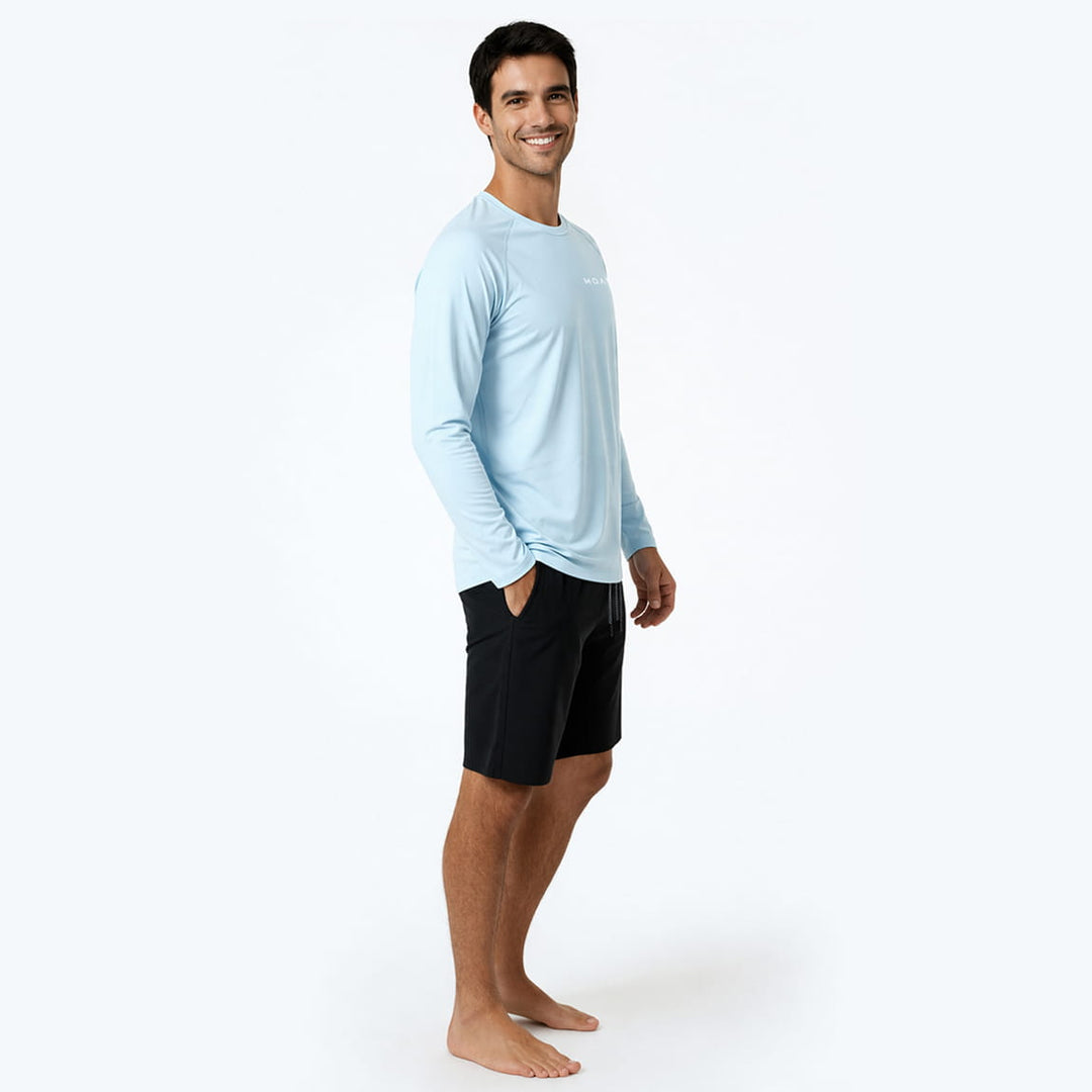 Man wearing a light blue long-sleeve rashguard 
and black shorts on a white background