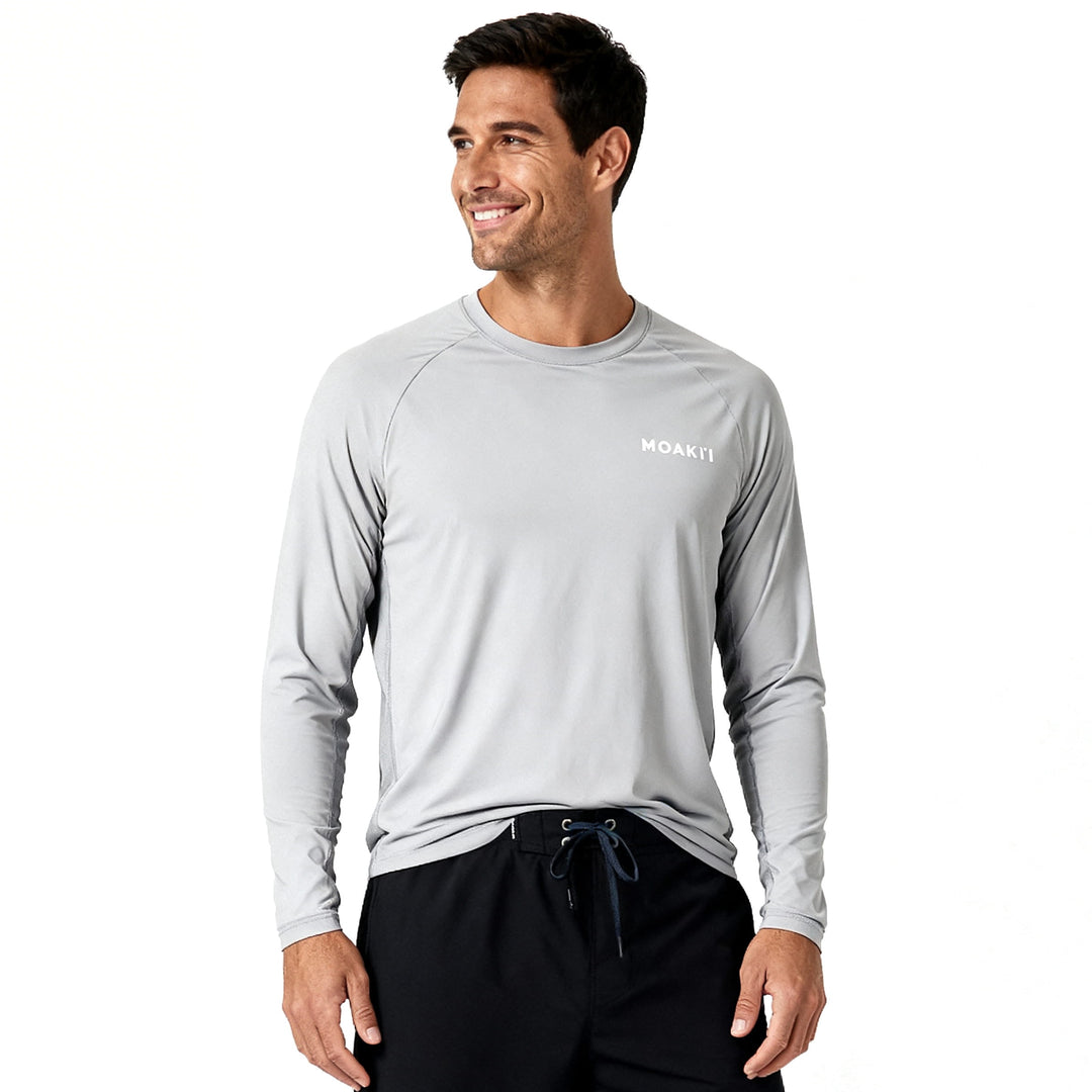 Man wearing a gray long-sleeve shirt with a brand logo on a white background