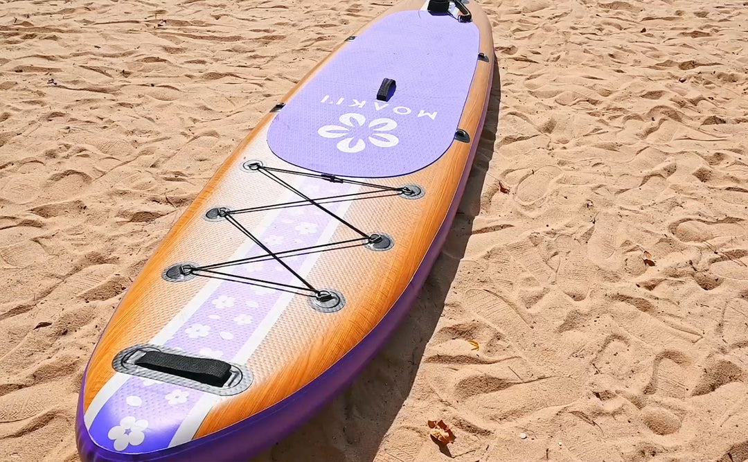 The Moaki'i Pathfinder resting on a beach, showing the beautiful wood-look aesthetic against a natural landscape.