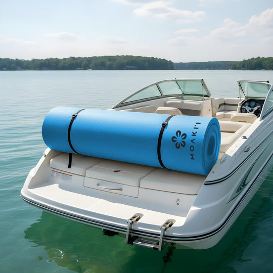 Blue large water mat on a boat on a lake with trees in the background