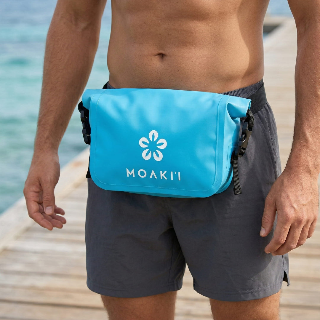 Person wearing a blue Moakii pouch on a beach