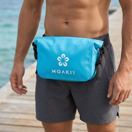 Person wearing a blue Moakii pouch on a beach