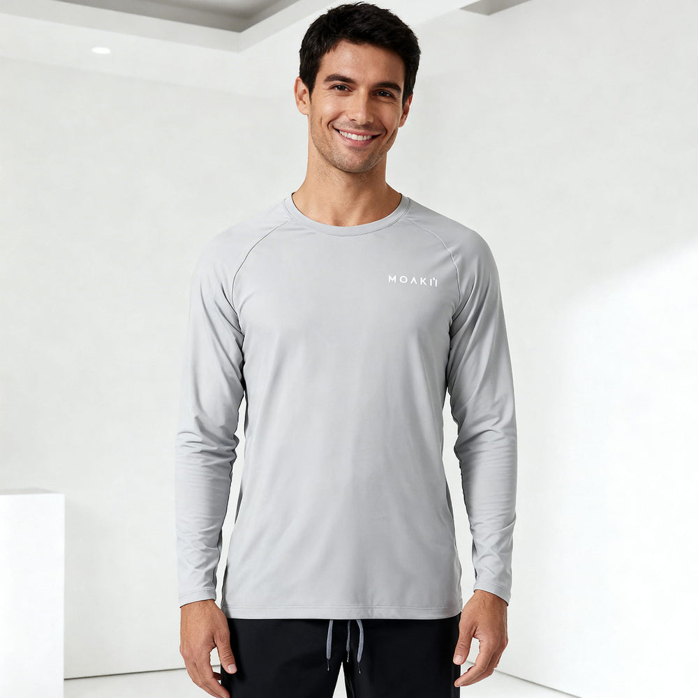 Man wearing a gray long-sleeve shirt with a brand logo on a white background