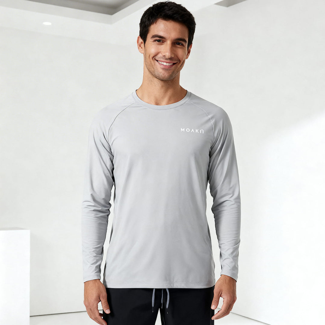 Man wearing a gray long-sleeve shirt with a brand logo on a white background