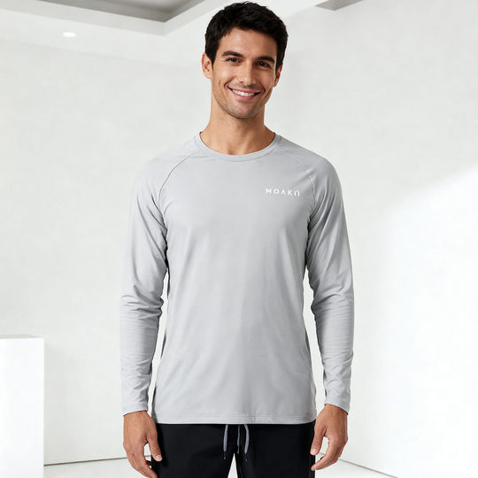 Man wearing a gray long-sleeve shirt with a brand logo on a white background