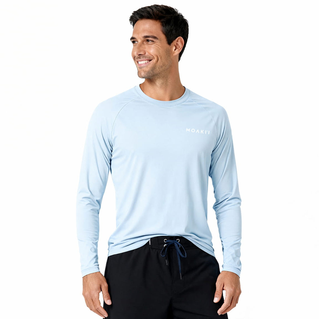 Man wearing a light blue long-sleeve shirt with a Moaki'i logo on a white background