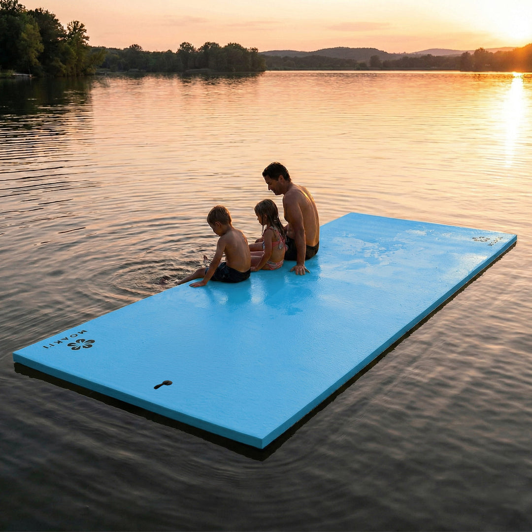 Family sitting on a blue floating platform in a lake at sunset