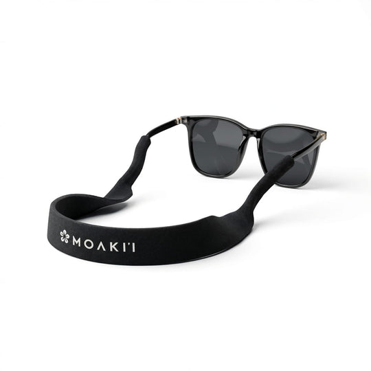 black neoprene strap for sunglasses attached to a pair of sunglasses on white background