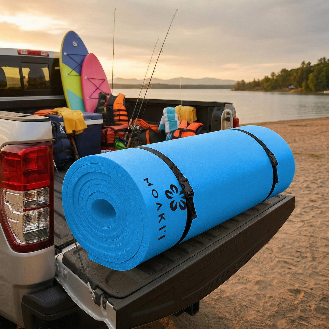Blue water mat with Moakii branding on a truck bed by a lake at sunset